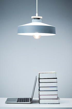 吊灯下的书和笔记本电脑图片