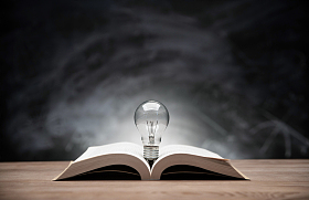 黑板前桌子上的书和灯泡图片