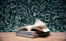 黑板画前的桌子上的书和眼镜图片