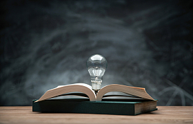 黑板前桌子上的书和灯泡