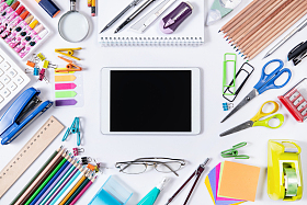 白色桌面上的学习用品和平板电脑