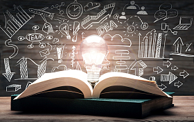 黑板画前打开的书和发光的灯泡