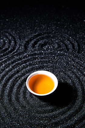 黑色背景下的一杯茶图片