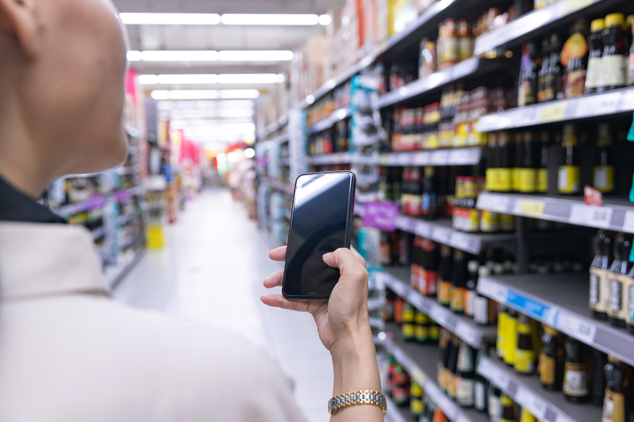 中年女性拿着手机在超市购物图片
