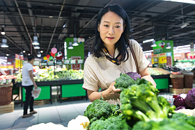 中年女性在超市挑选蔬菜图片