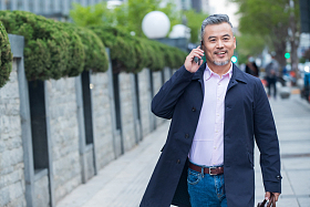 户外拎着公文包打电话的商务中老年男子