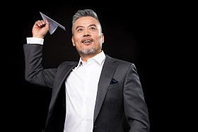 中老年商务男士拿着纸飞机