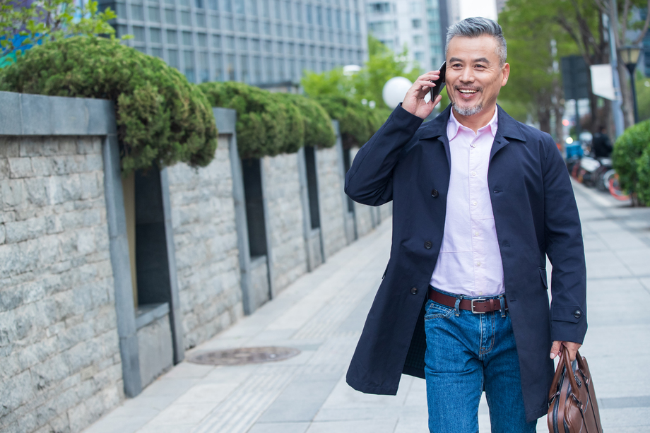 户外拎着公文包打电话的商务中老年男子 户外拎着公文包打电话的商务中老年男子