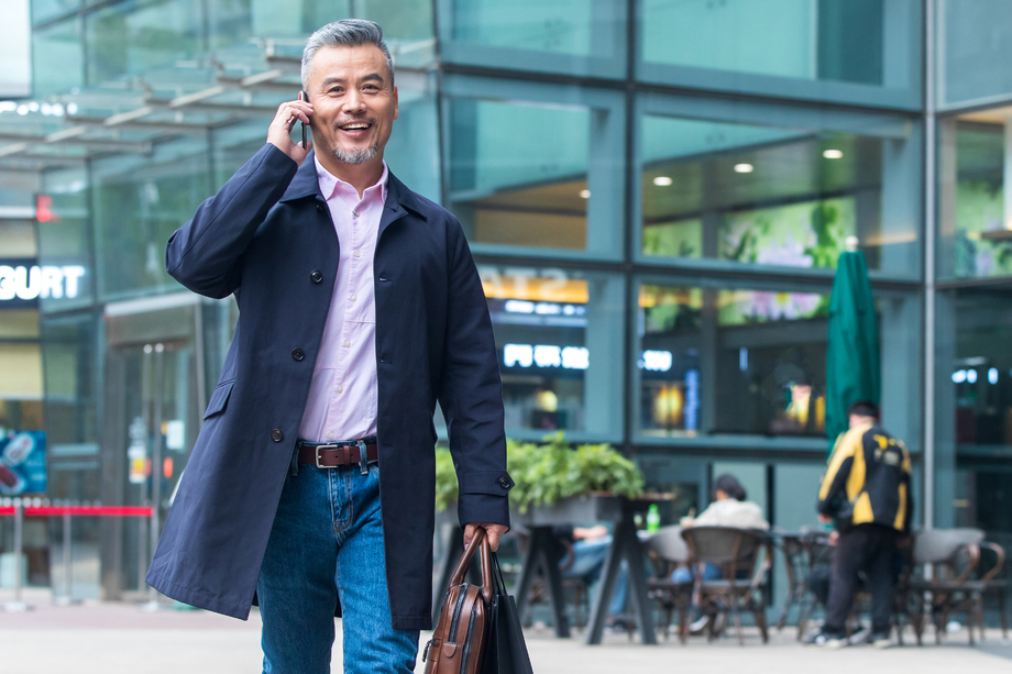 户外拎着公文包打电话的商务中老年男子 户外拎着公文包打电话的商务中老年男子