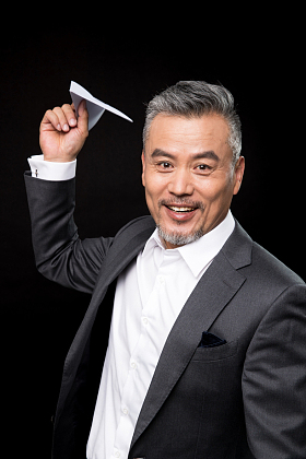 中老年商务男士拿着纸飞机