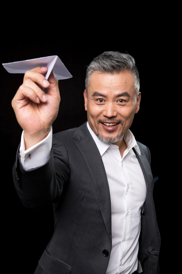 快乐的中老年商务男士拿着纸飞机 快乐的中老年商务男士拿着纸飞机