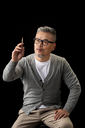 资深设计师坐在椅子上拿着铅笔