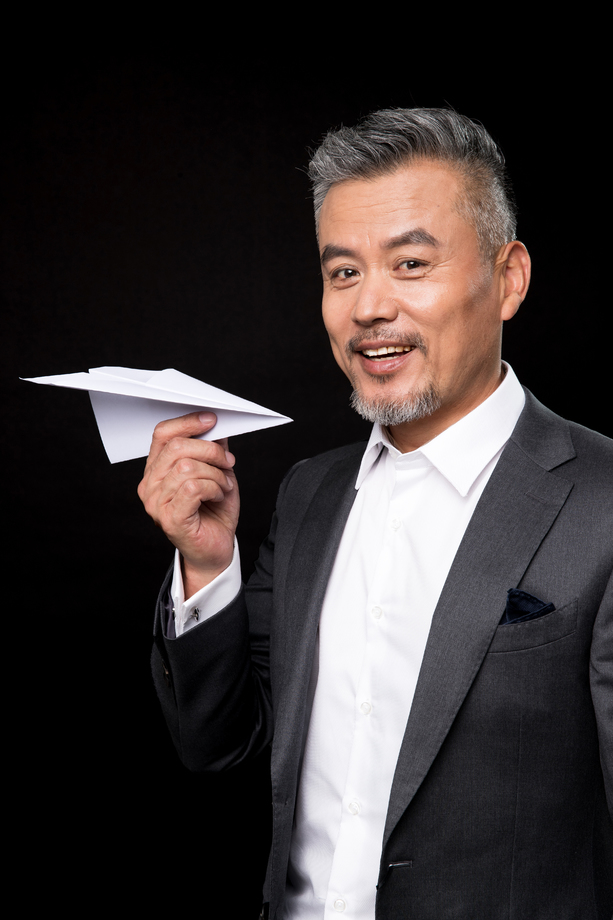 快乐的中老年商务男士拿着纸飞机 快乐的中老年商务男士拿着纸飞机