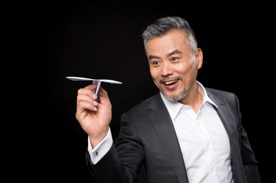 快乐的中老年商务男士拿着纸飞机 快乐的中老年商务男士拿着纸飞机