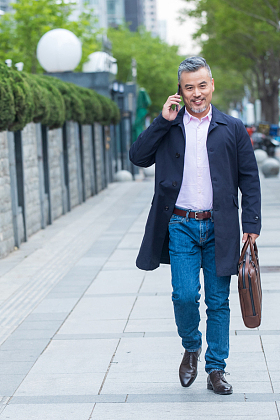户外拎着公文包打电话的商务男士