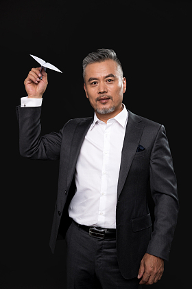 中老年商务男士拿着纸飞机