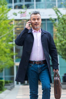 户外拎着公文包打电话的商务男士