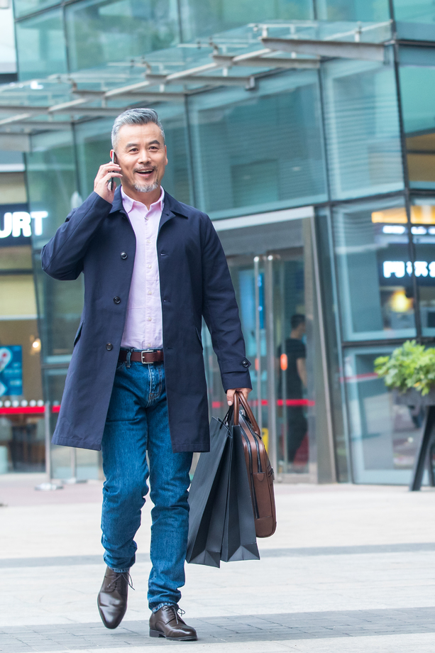 拎着包逛街购物打电话的商务男士 拎着包逛街购物打电话的商务男士