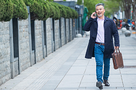 街道上拎着公文包打电话的商务男士