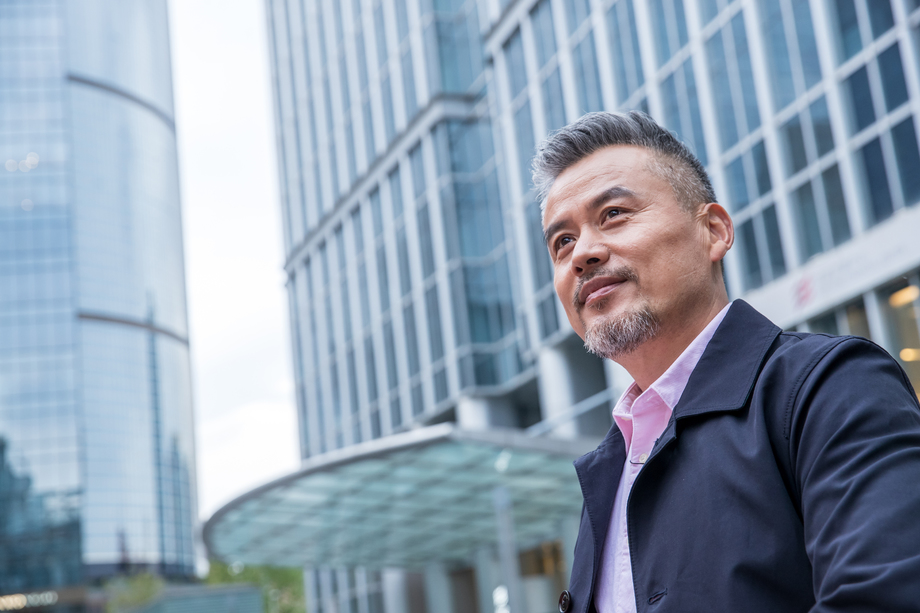 中老年商务男士站着楼群中间图片 中老年商务男士站着楼群中间图片