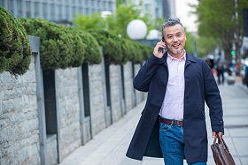 街道上拎着公文包打电话的商务男士