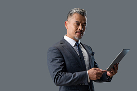 拿着平板电脑自信的商务男士照片