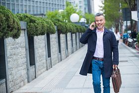 街道上拎着公文包打电话的商务男士