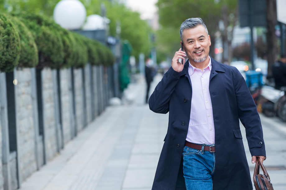 街道上拎着公文包打电话的商务男士 街道上拎着公文包打电话的商务男士