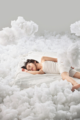 可爱的小女孩躺在云朵上照片