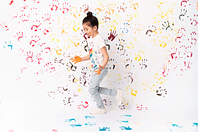 手上涂满颜料画画的小女孩