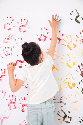 手上涂满颜料画画的小女孩图片