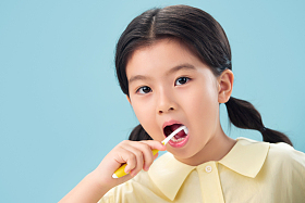 拿着牙刷刷牙的小女孩照片