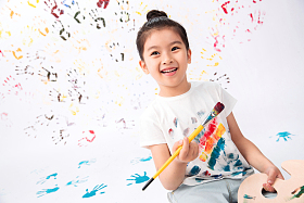 拿画笔画画的小女孩图片