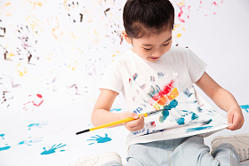 拿画笔画画的小女孩图片