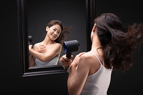 中年女人用吹风机吹头发