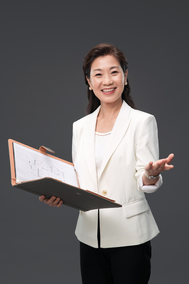 拿着户型图册做出邀请手势的成熟商务女士 拿着户型图册做出邀请手势的成熟商务女士