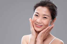 双手触摸脸颊的中年女人图片