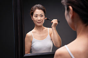 对着镜子化妆的中年女人
