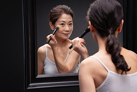 对着镜子化妆的中年女人