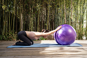 户外扶着瑜伽球练瑜伽中老年女士
