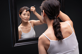 对着镜子化妆的中年女人图片