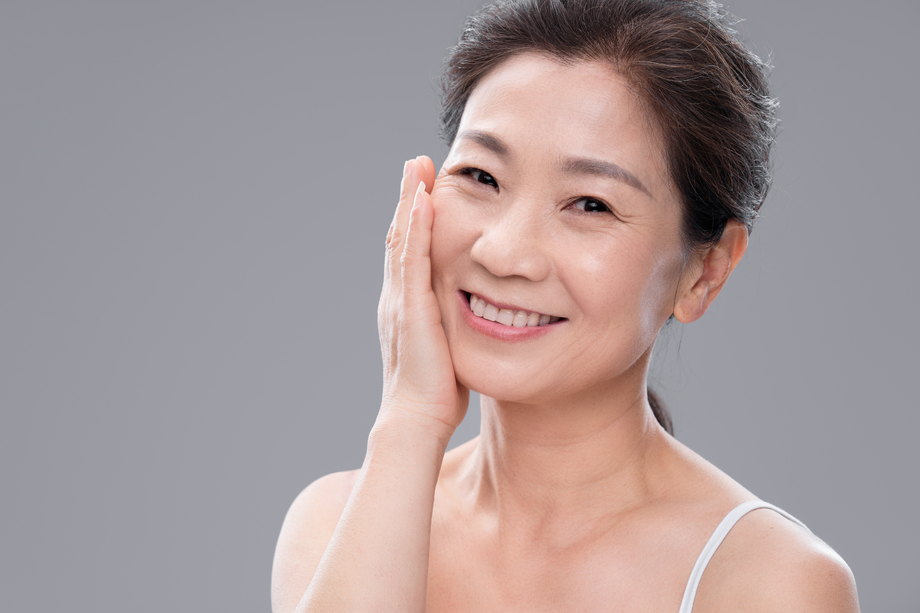 用手抚摸脸颊的优雅中年女人图片