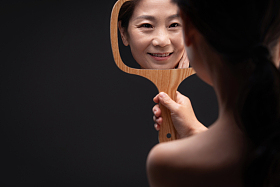 拿着镜子照的中年女人照片