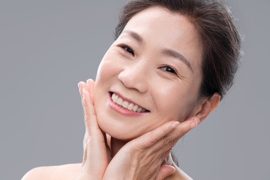 用双手触摸脸颊的优雅中年女人 用双手触摸脸颊的优雅中年女人