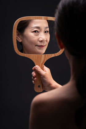 拿着镜子照的中年女人图片
