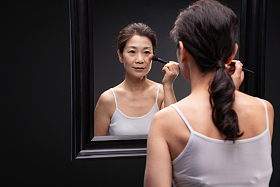 对着镜子化妆的中年女人