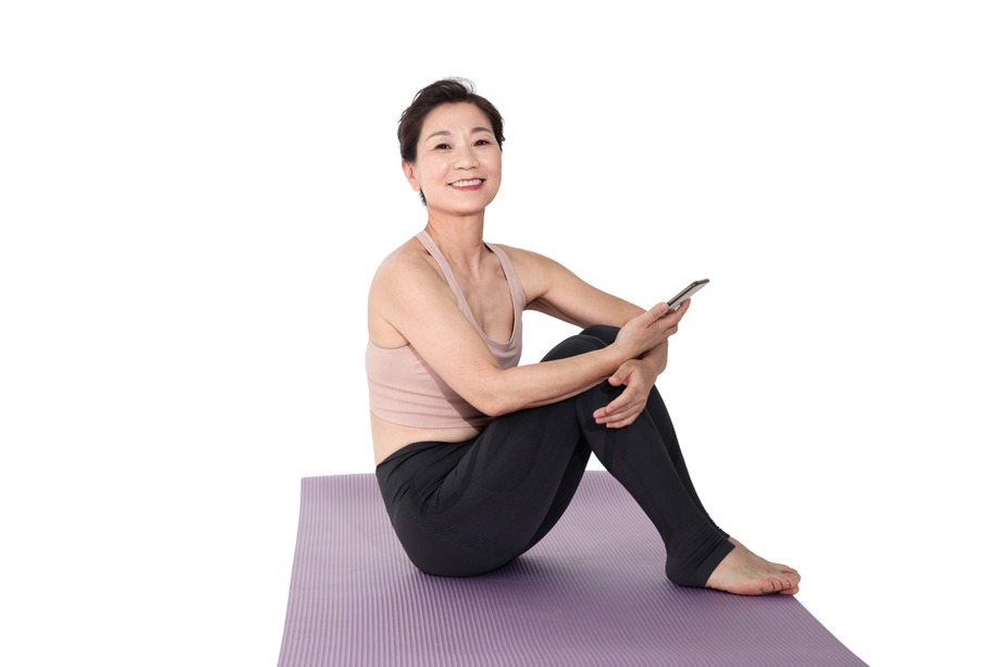 坐在瑜伽垫上休息的中老年女人 坐在瑜伽垫上休息的中老年女人