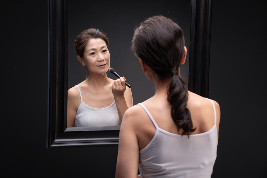 对着镜子化妆的中年女人 对着镜子化妆的中年女人