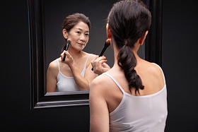 对着镜子化妆的成熟女人