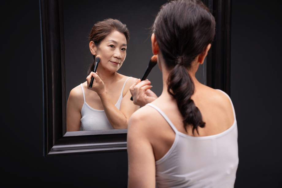 对着镜子化妆的成熟女人